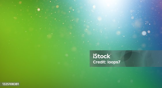 istock Natural Green Blue Gradient Background with Defocused Lights and Particles 1325108381