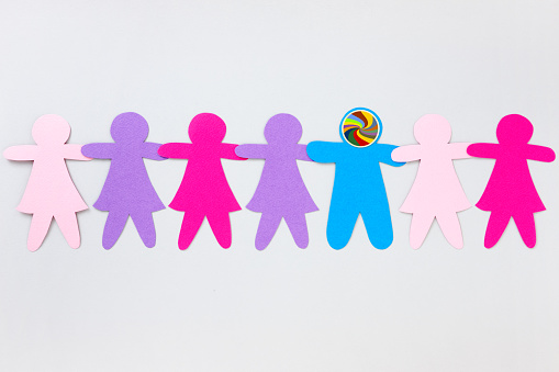 Paper cuts of pink shaded girls holding hands side by side with a blue boy with a swirling pattern on his head