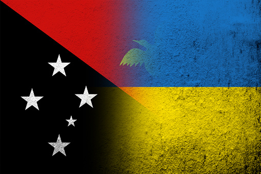 The Independent State of Papua New Guinea National flag with National flag of Ukraine. Grunge background