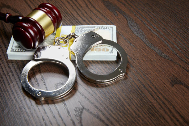 MONEY, GAVEL AND HANDCUFFS ON WOOD stock photo
