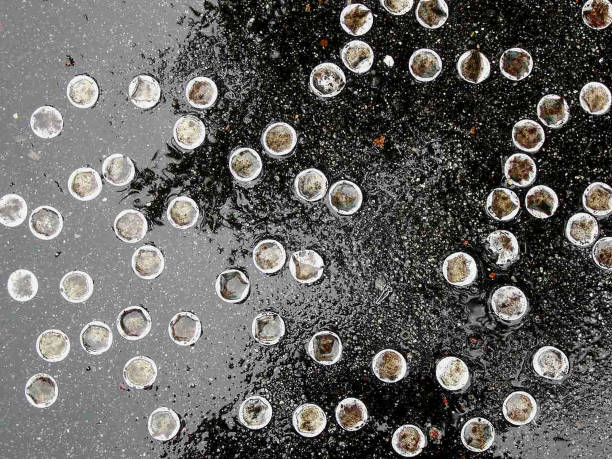 BOTTLE CAPS IN PAVEMENT stock photo