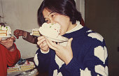 1980年代の中国人女性がバースデーケーキを食べる実生活の写真