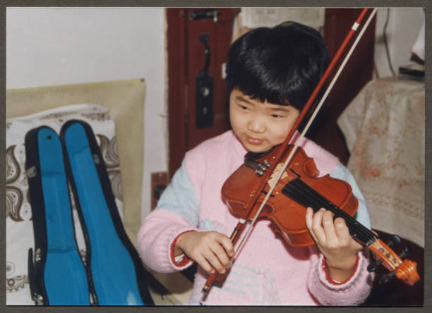 1990s Chinese Little girl practicing violin 1990s Chinese Little girl practicing violin 1991 stock pictures, royalty-free photos & images