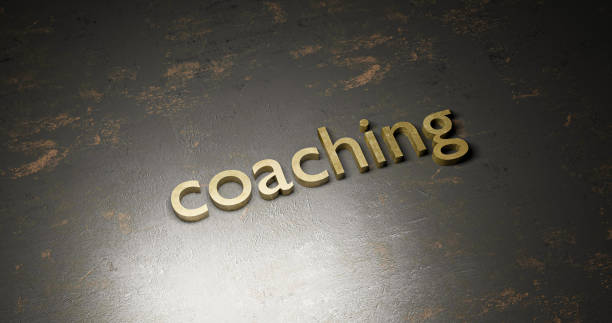 3d rendering gold - coaching - written on textured rustic black metal positioned in a diagonal line stock photo