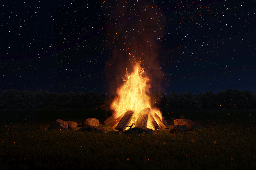 3d rendering of big bonfire with sparks and particles in front of forest and starry sky