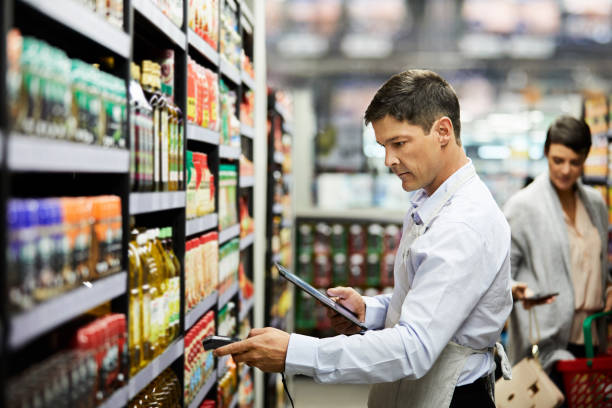 4k-videoaufnahmen eines filialmitarbeiters, der produkte in einem supermarkt scannt - food data stock-fotos und bilder