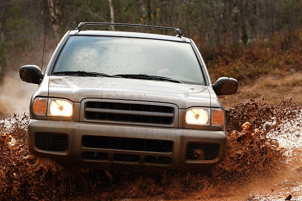 4x4 sport utility vehicle exploring muddy road stock photo