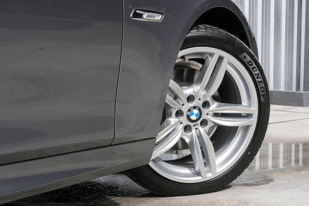 BMW 520d Wheel with DUNLOP tire Chiang Mai,Thailand - December 20, 2012:The front wheel of a BMW 520d saloon parked on display outside of a car dealership. bmw stock pictures, royalty-free photos & images