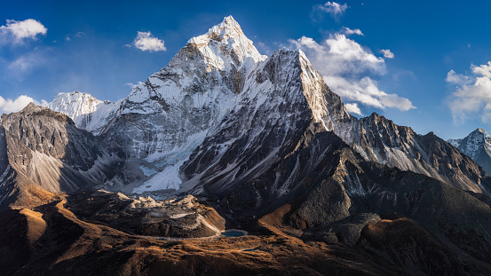 75MPix XXXXL size panorama of Mount Ama Dablam - probably the most beautiful peak in Himalayas. \n This panoramic landscape is an very high resolution multi-frame composite and is suitable for large scale printing\nAma Dablam is a mountain in the Himalaya range of eastern Nepal. The main peak is 6,812  metres, the lower western peak is 5,563 metres. Ama Dablam means  'Mother's neclace'; the long ridges on each side like the arms of a mother (ama) protecting  her child, and the hanging glacier thought of as the dablam, the traditional double-pendant  containing pictures of the gods, worn by Sherpa women. For several days, Ama Dablam dominates  the eastern sky for anyone trekking to Mount Everest basecamp