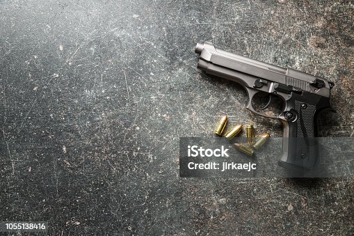istock 9mm pistol bullets and handgun 1055138416
