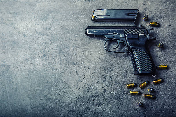 9mm pistol gun and bullets strewn on the table - vuurwapen stockfoto's en -beelden