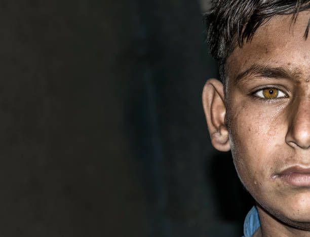 kör bir genç çocuk siyah gözlük takıyor - migrants stok fotoğraflar ve resimler