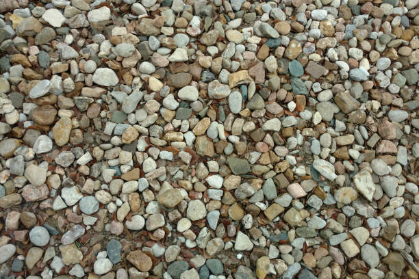 a close up view of a stone pebble rock gravel garden path backyard trail suitable for background backdrop also like a footpath walkway park featuring overhead detail textured surface pattern stock photo