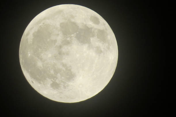 a  closeup of a full moon showing craters stock photo