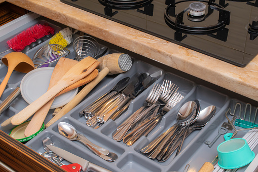 a drawer with kitchen utensils, spoons and forks