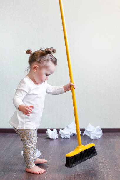 a girl holds a broom for 1.5 years, the concept of house cleaning,...
