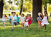 istock a group of preschoolers running on the grass in the Park 1367828290