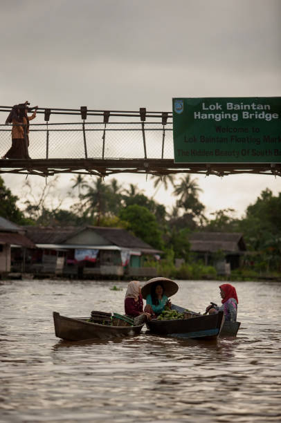 a group of sellers and buyers are discussing under the Lokbaintan hanging bridge stock photo