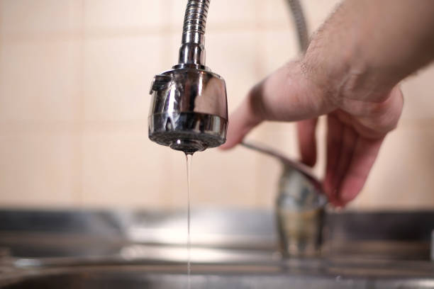 a man opens a faucet in the kitchen, but no water comes. Overlapping water a man opens a faucet in the kitchen, but no water comes. Overlapping water, shutting off water supply. Close-up arid climate stock pictures, royalty-free photos & images