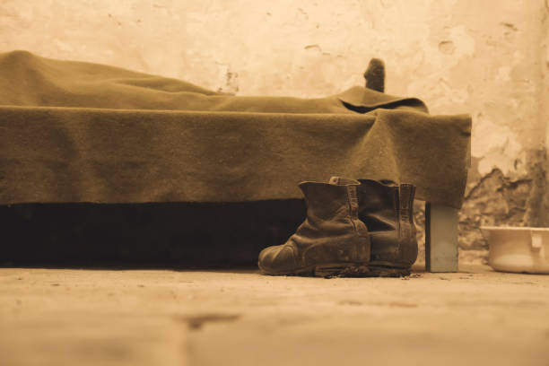 a pair of boots beside a bed - prision imagens e fotografias de stock