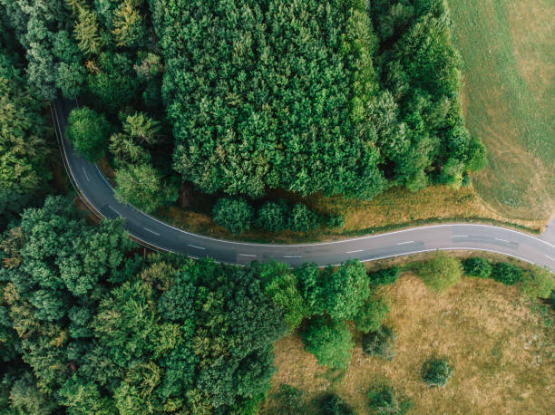 a road with a curve aerial view of a road with a curve at a forest odenwald stock pictures, royalty-free photos & images
