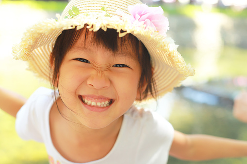 a smiling Asian girl playing in a park. portrait of Taiwan girl.