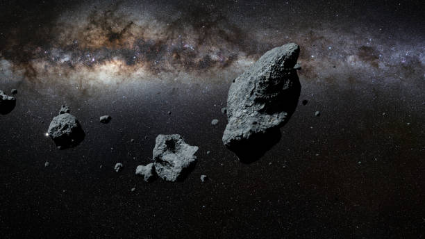 a swarm of asteroids in front of the Milky Way galaxy stock photo