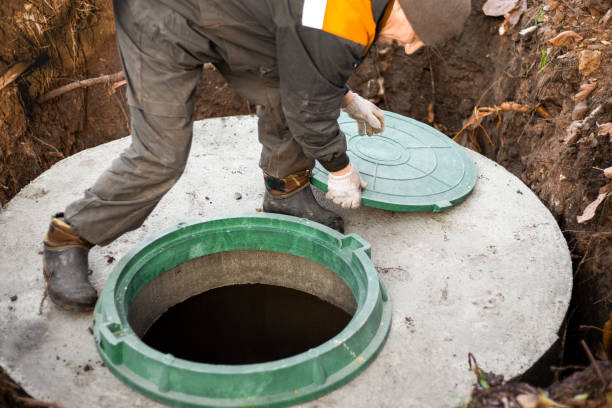 a utility worker opened a well hatch for sewerage maintenance and pumping out feces. Septic on a residential lot stock photo