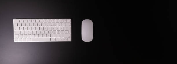 a white keyboard and mouse on a black table stock photo