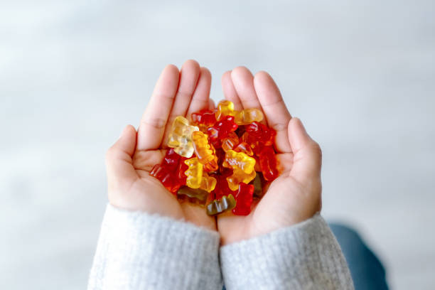 a woman holding colorful Jelly gum in hands Top view image of a woman holding colorful Jelly gum in hands candy stock pictures, royalty-free photos & images