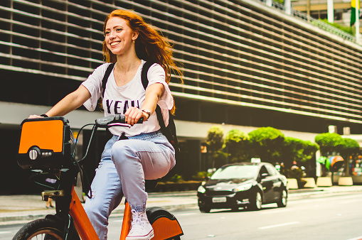 a young woman with red hair, on the cycle path of avenue paulista