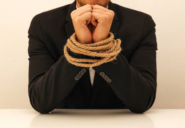 a young business man with tied hands business man with tied hands hands tied up stock pictures, royalty-free photos & images
