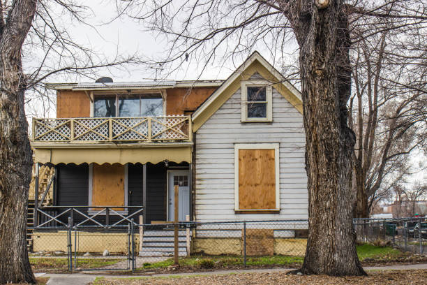 Abandoned Two Story House With Boarded Up Windows Abandoned Corner Two Story House With Boarded Up Windows foreclosure stock pictures, royalty-free photos & images