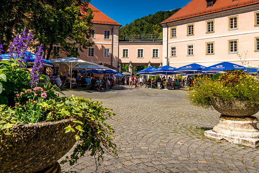 Regensburg, Germany - August 20, 2020: View of the beer garden in the very famous abbey called Kloster Weltenburg in Kelheim - near Regensburg in Germany. One of the oldest beer breweries in Germany. Picture  shows people eating and drinking in the beer garden.
