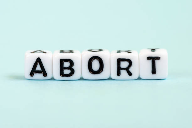 abortar la palabra escrita en cubos. fondo azul médico - abortion clinic fotografías e imágenes de stock