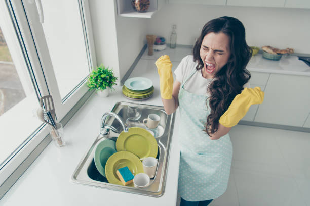 Above high angle view of her she attractive beautiful irritated annoyed fury frustrated devastated wavy-haired house-wife showing rage gesture near dirty plates pile in modern light white interior Above high angle view of her she attractive beautiful irritated annoyed fury frustrated devastated wavy-haired house-wife showing rage gesture near dirty plates pile in modern light white interior chores photos stock pictures, royalty-free photos & images