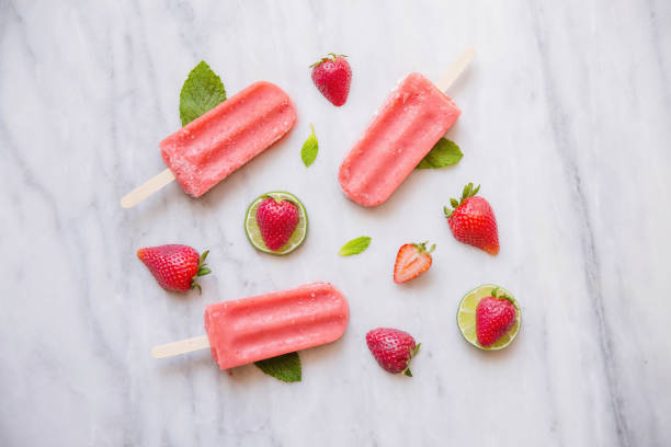 Above shot of Red Popsicles and Fruit on Marble stock photo