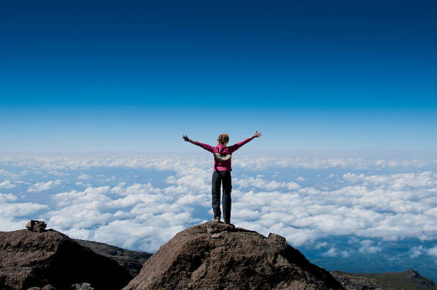 Above the clouds on Kilimanjaro A happy trekker above the clouds on the route to the summit of Kilimanjaro mt kilimanjaro photos stock pictures, royalty-free photos & images