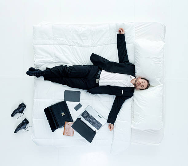 Above view of businessman sleeping on bed Above view of businessman sleeping on bedhttp://www.twodozendesign.info/i/1.png man sleeping in bed top view stock pictures, royalty-free photos & images