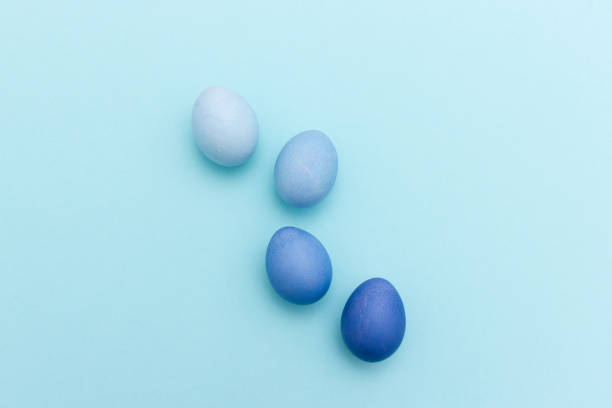Above view of group of four colored easter eggs in shades of blue stock photo