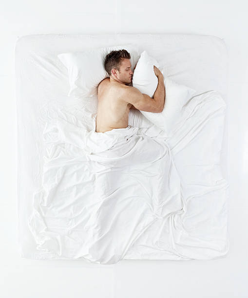 Above view of muscular man sleeping on bed Above view of muscular man sleeping on bed man sleeping in bed top view stock pictures, royalty-free photos & images