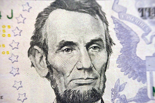 Abraham Lincoln portrait on the banknote of 5 dollars, five American dollars background, selective focus, united states