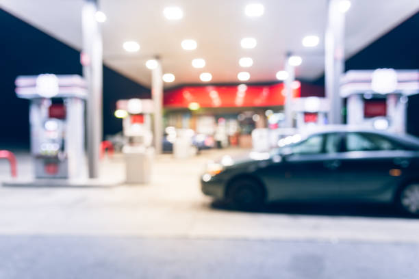 Abstract blurred gas station with car refueling at night stock photo