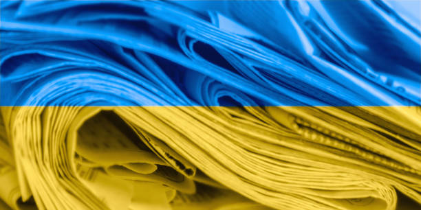 Abstract, blurred image of newspapers on the background of the flag of Ukraine. News media concept. panoramic image. stock photo