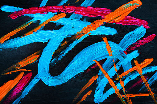 Bright yellow, blue and red colored abstract acryl painting on black background. 2020 color trend.