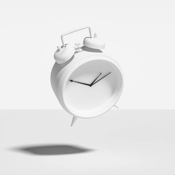 Abstract Image of White Painted Vintage Alarm Clock, Falling, Floating, Suspended, Isolated Against White stock photo
