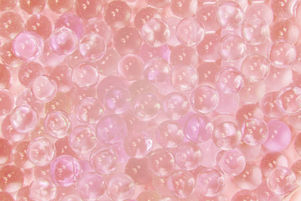 Abstract texture of transparent glass balls with pink ink or lump of marbles. Collagen Hydrolysate. Hyaluronic acid skin solutions ad, collagen serum drop with space cosmetic advertising ready. Abstract texture of transparent glass balls with pink ink or lump of marbles. Collagen Hydrolysate. Hyaluronic acid skin solutions ad, pink collagen serum drop with space cosmetic advertising ready. collagen stock pictures, royalty-free photos & images