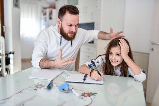 Abusive Father Letting Anger Out At Female Child Writing Homework