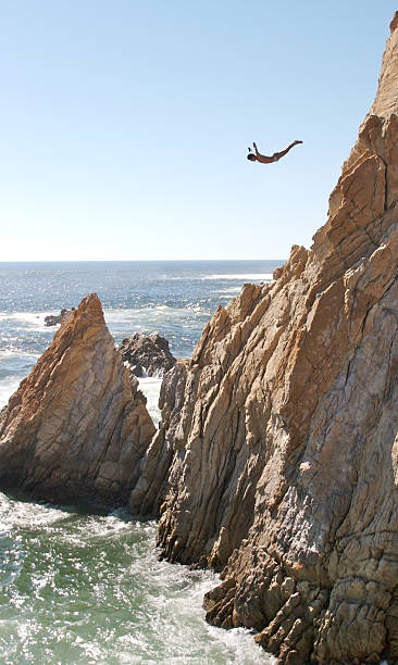 Acapulco Cliff Diver Cliff Diver jumps in Acapulco cliff jumping stock pictures, royalty-free photos & images