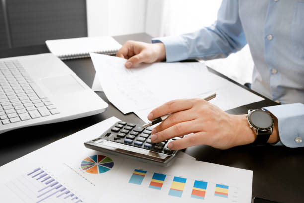 Accountant at work. Concept of budget and savings Accountant at work in the office. Man calculates income and expenses. Concept of budget and savings expense stock pictures, royalty-free photos & images